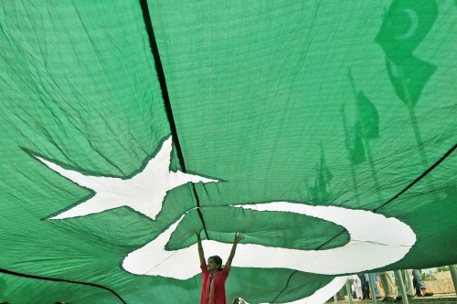 A Pakistani girl stands under a huge national flag unfurled in front of the Minar-e-Pakistan, the historic monument for the struggle for independence, ahead of the country's Independence Day in Lahore on August 13, 2013. Pakistan will be celebrating its 66th anniversary of the country's independence from British rule on August 14. AFP PHOTO / ARIF ALI (Photo credit should read Arif Ali/AFP/Getty Images)